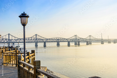 Yalu River Bridge and Yalu River Scenic Areas at morning. In the distance is North Korea. Located in Dandong, Liaoning, China. © aphotostory