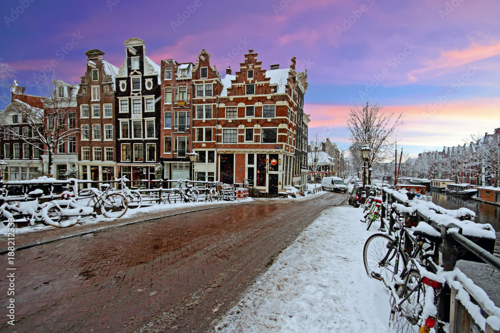 Obraz premium Snowy Amsterdam in the Netherlands in winter at sunset