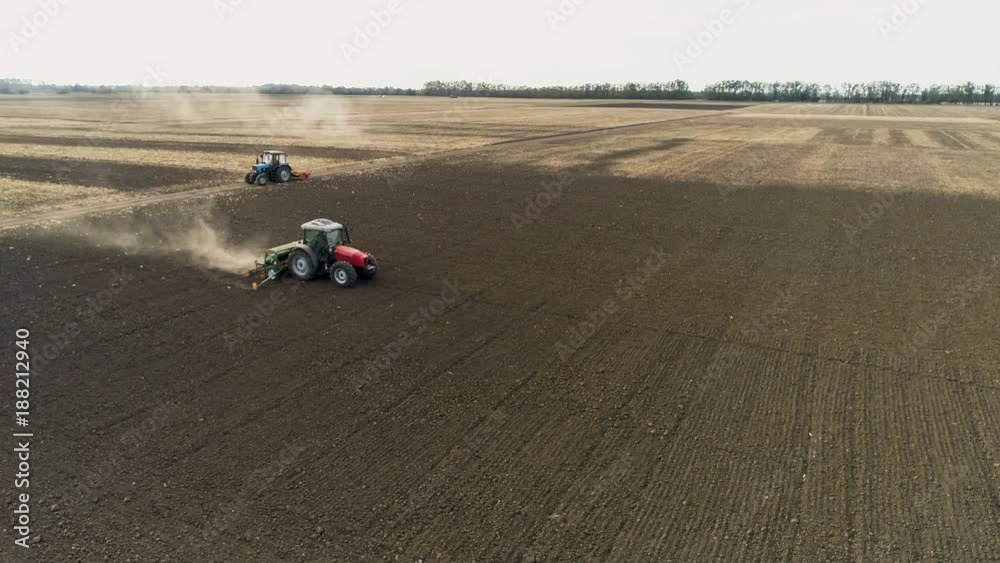 Red Tractor Mounted Seed Drill Plants the Seeds in the Soil in the Experimental Field. Aerial View Red Tractor Mounted Seed Drill Plants the Seeds in the Soil in the Experimental Field. Aerial View
