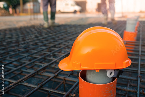 Orange safety helmet at construction site with blurry background
