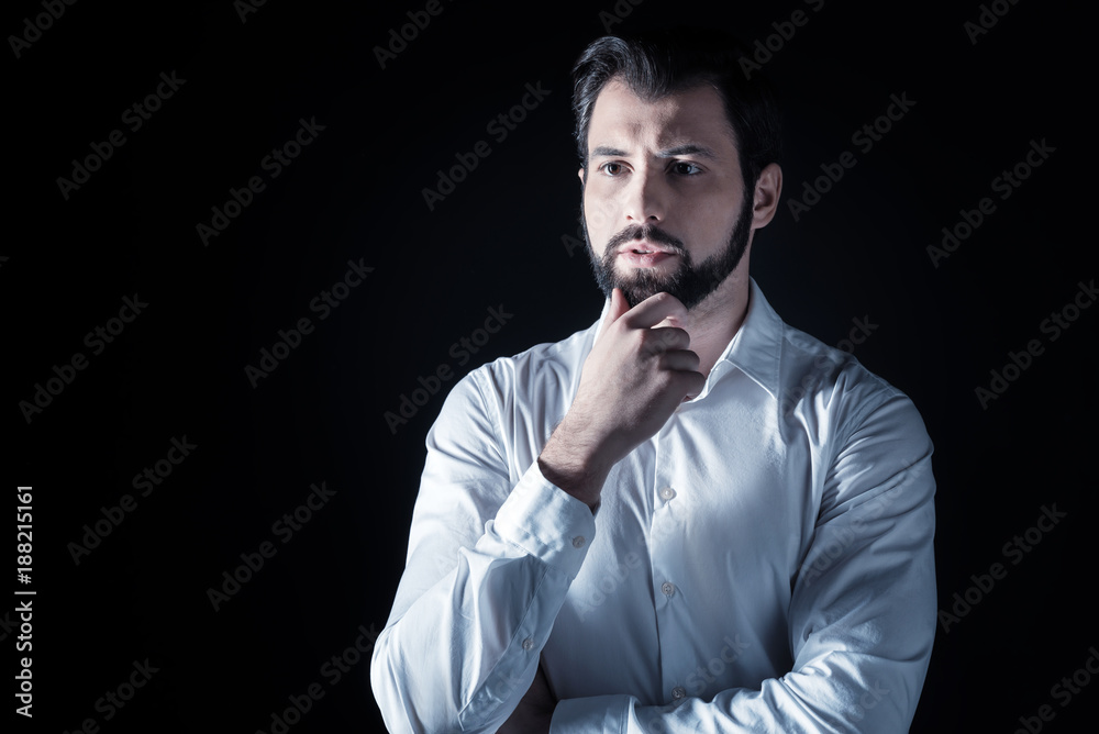 Pensive look. Smart nice handsome man standing against black background and thinking while looking for a solution Pensive look. Smart nice handsome man standing against black background and thinking while looking for a solution
