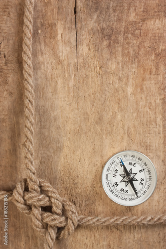 compass and rope knot on wooden background