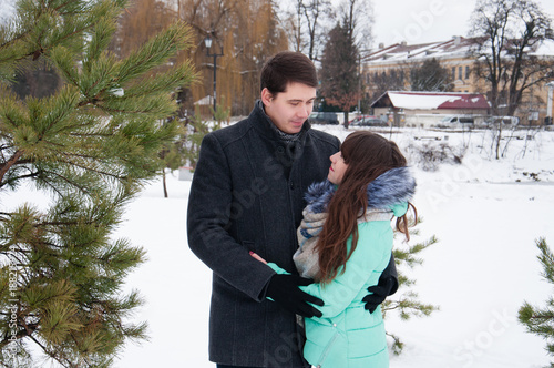 A loving couple is walking in the winter city park photo