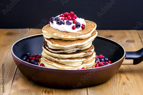 Stack of American Pancakes with Cranberry and Blueberry on Pan Wooden Rustic Background Tasty Breakfast