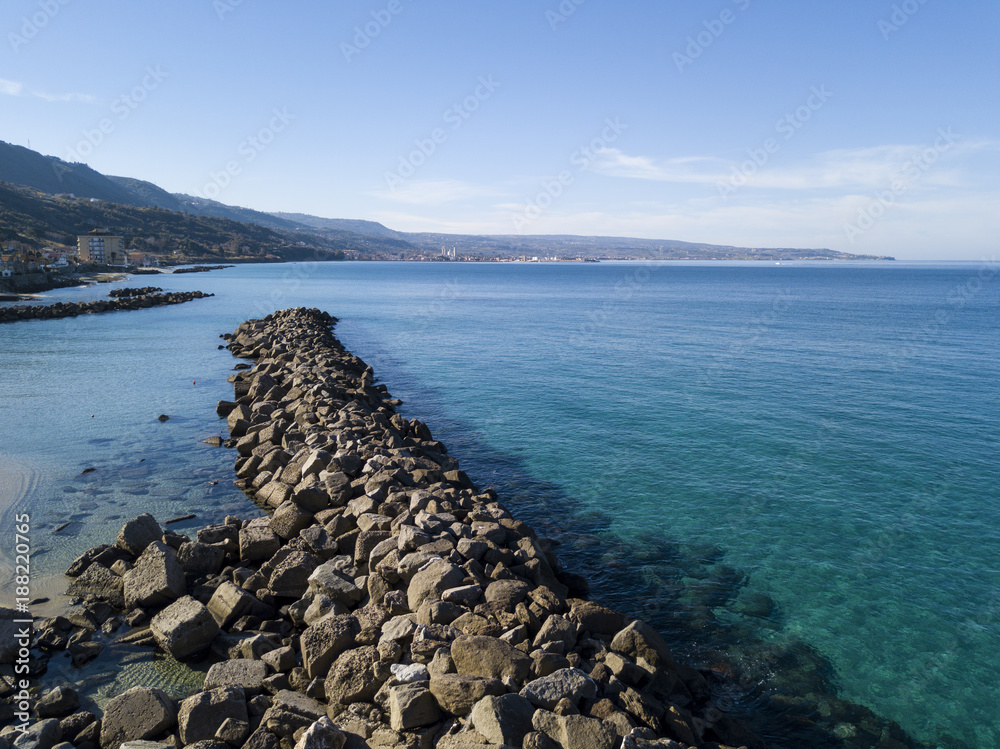 Vista aerea di un molo con rocce e scogli sul mare. Molo di Pizzo Calabro panoramica vista dall’alto. Mare e turismo sulle coste calabre del sud Italia. Calabria, Italia