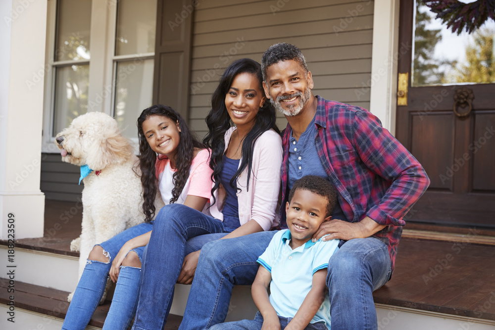 Family With Children And Pet Dog Sit On Steps Of Home Family With Children And Pet Dog Sit On Steps Of Home
