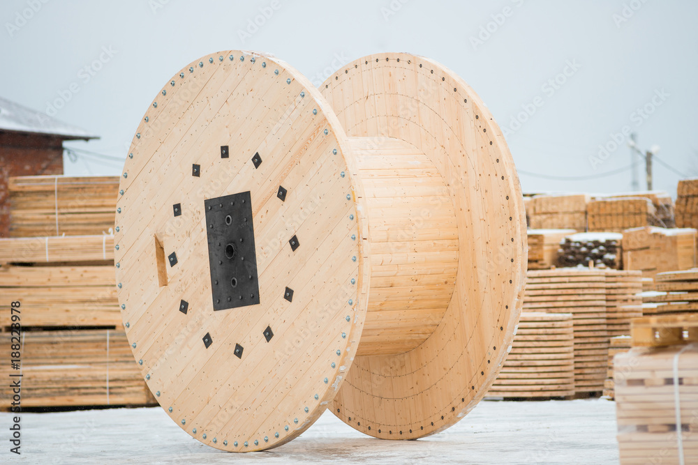 Large empty wooden coil. The new cable drum at the industrial area.  Outdoors Stock Photo