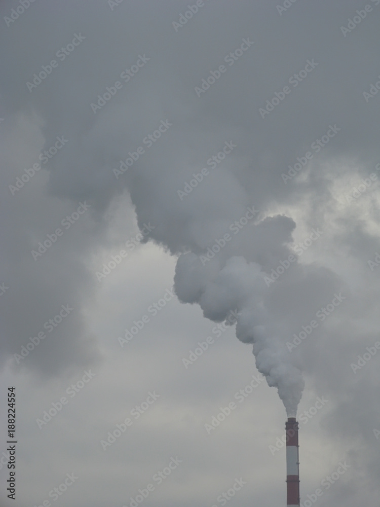 Industrial Smoke Pipe on a Grey Sky / Smoke air emissions from an CHP pipe on a grey sky in windless winter day Industrial Smoke Pipe on a Grey Sky / Smoke air emissions from an CHP pipe on a grey sky in windless winter day