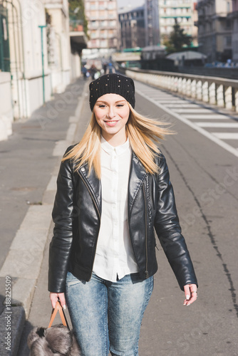young woman beautiful blonde hair walking outdoor looking away smiling - happiness, everyday life, girl power concept