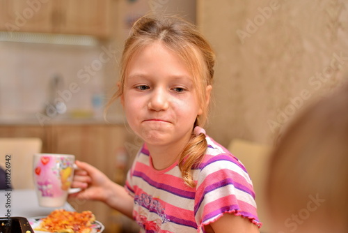 girl with pigtails eating pizza at home. happy girls eats pizza on white background