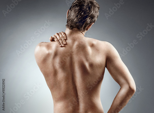 Young man holding his neck in pain. Medical concept.