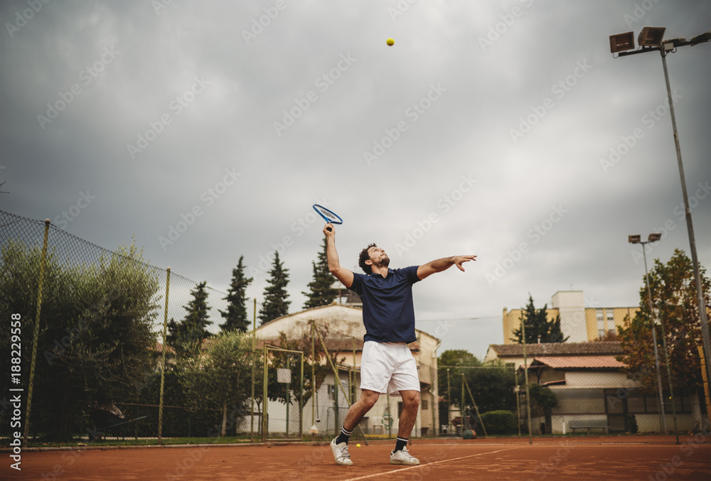 Young man engaged in the tennis service during a match Young man engaged in the tennis service during a match