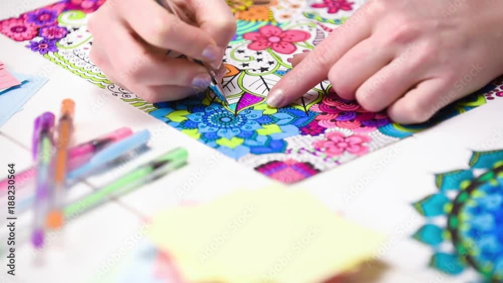 Colour video of a young unrecognisable woman colouring in an adult colouring book. New art therapy and stress management trend. Close up shot, hand detail. Colour video of a young unrecognisable woman colouring in an adult colouring book. New art therapy and stress management trend. Close up shot, hand detail.