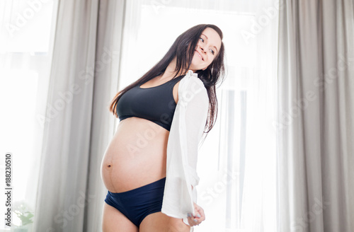 Happy smiling pregnant woman at home dancing near window Free Download Happy smiling pregnant woman at home dancing near window - GFXLoad