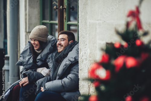 Classy groom and his gorgeous bride pose outside in winter coats 