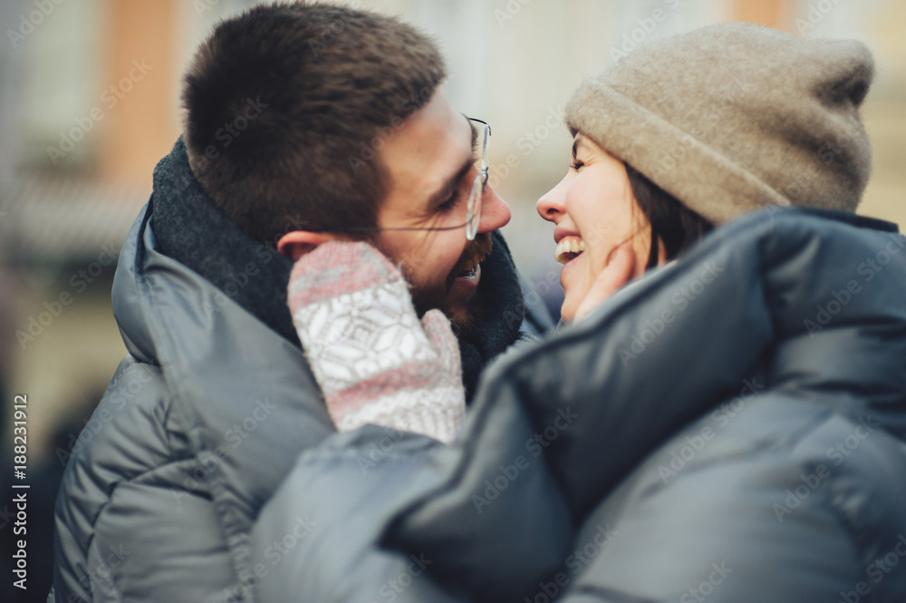 Fototapeta premium Classy groom and his gorgeous bride pose outside in winter coats 