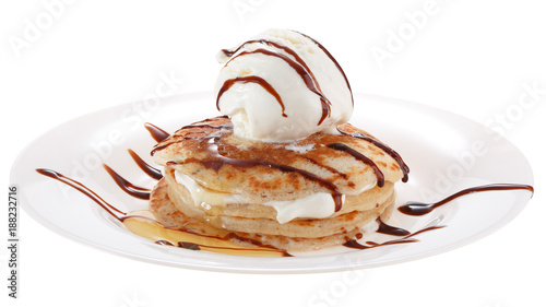 Serving pancakes with ice cream on the plate. Decorated with chocolate syrup and honey. Isolated on white background.