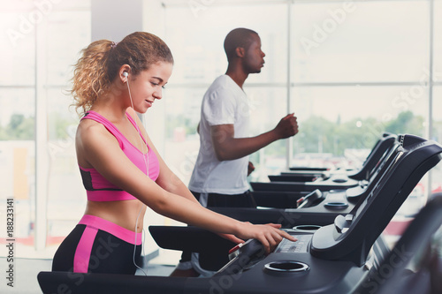 Man and woman, couple in gym on treadmills