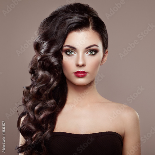 Brunette Woman with Curly Hairstyle. Beautiful Girl with long Wavy Hair. Perfect Makeup. Fashion photo