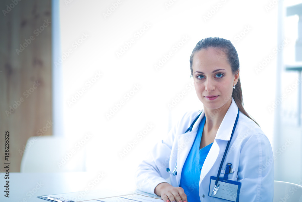 Portrait of young female doctor sitting at desk in hospital . female doctor. Portrait of young female doctor sitting at desk in hospital . female doctor.