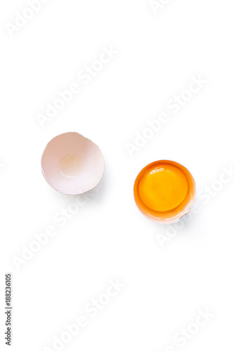 fresh brown organic chicken egg broken with yolk and egg white isolated on white background. Vertical composition. Top view