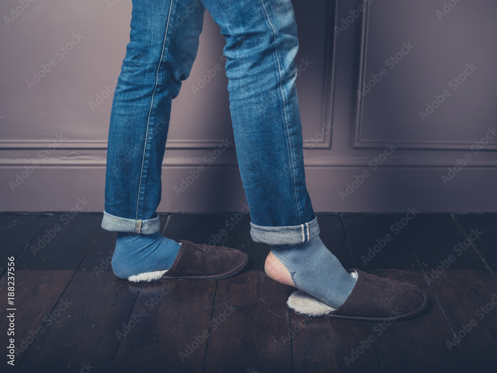 Young man with slippers on wooden floor Young man with slippers on wooden floor