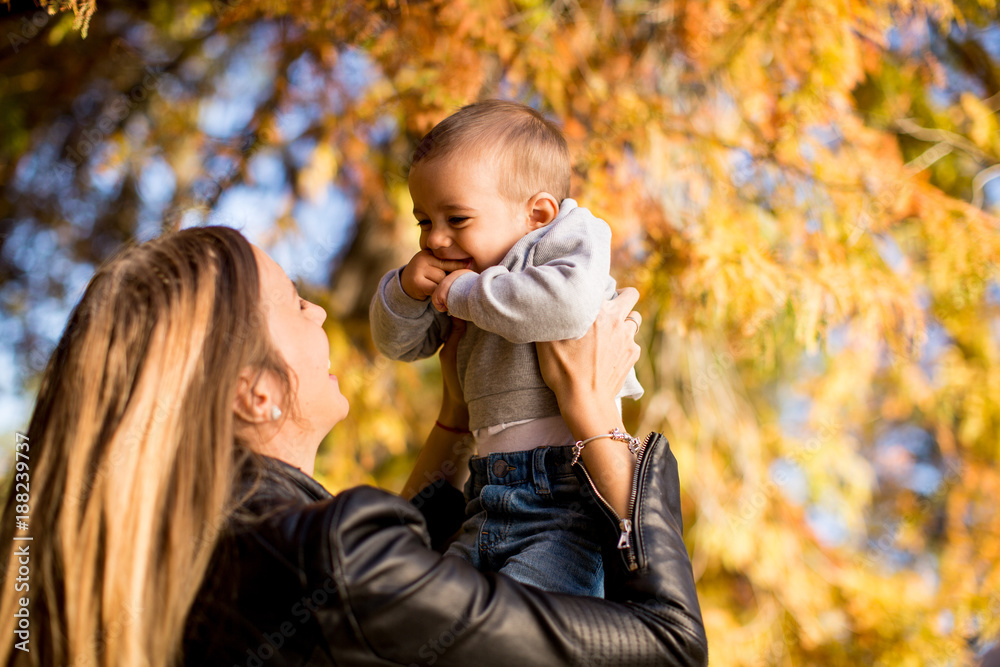 Young mother and baby boy in autumn park Young mother and baby boy in autumn park
