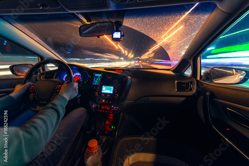 Fototapeta Naklejka Na Ścianę i Meble -  Movement of the car at night at a speed view from the interior, Brilliant road with lights with a car at high speed