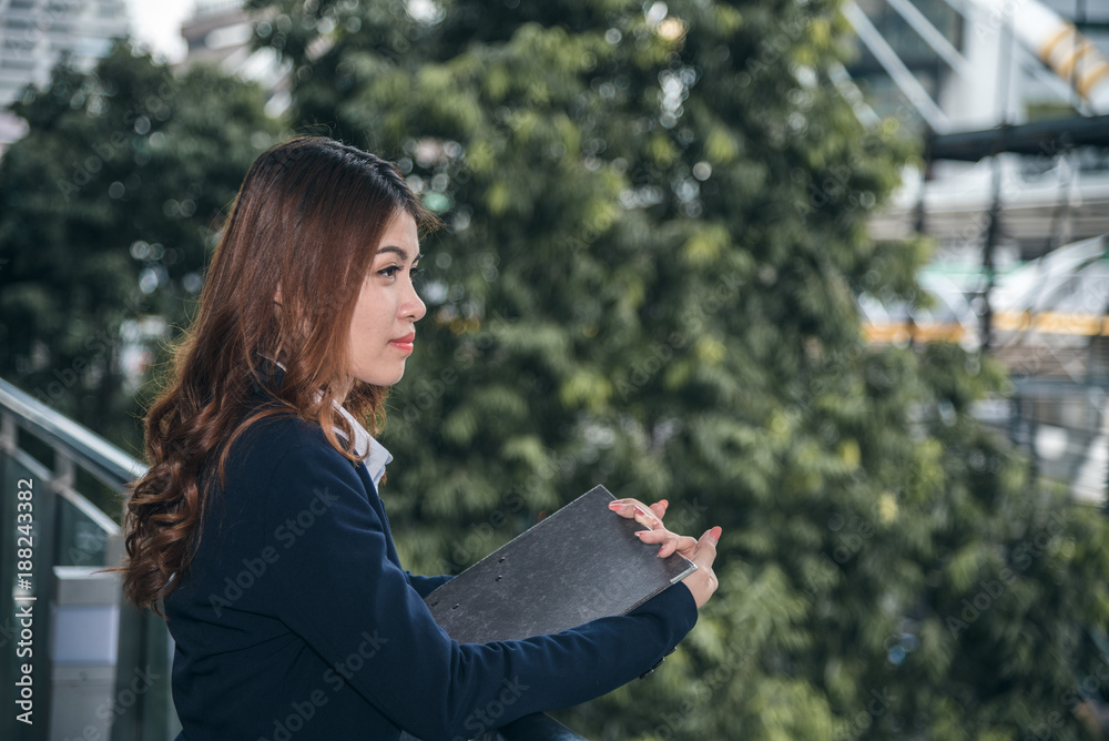 Portraits of beautiful asian woman with document folder on outdoor in urban Portraits of beautiful asian woman with document folder on outdoor in urban