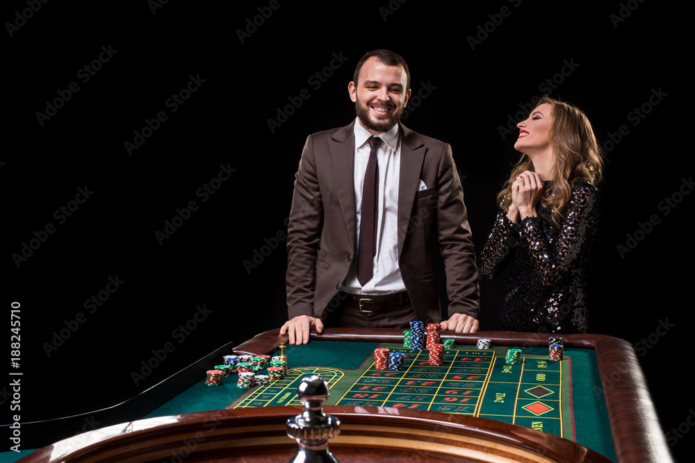 Man and woman playing at roulette table in casino
