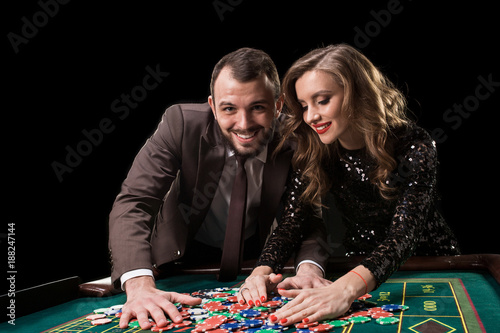 Man with woman playing roulette at the casino. Addiction to the  photo