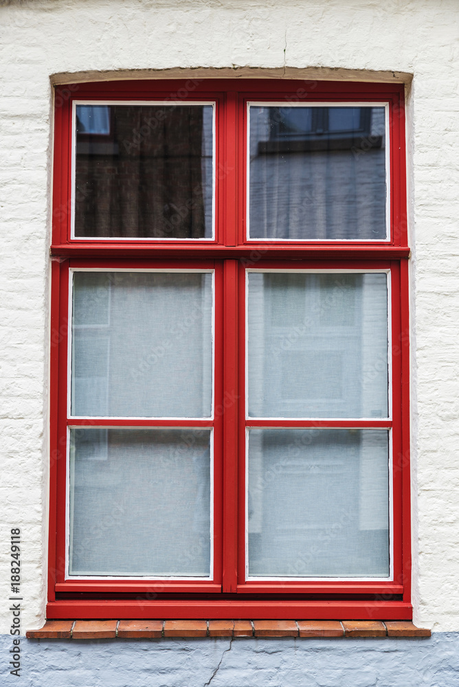 Red window of an old classic building in Bruges, Belgium