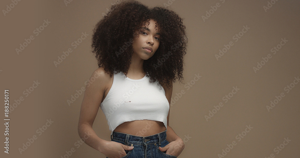 Φωτογραφία mixed race black woman portrait with big afro hair, curly hair in beige backgrou