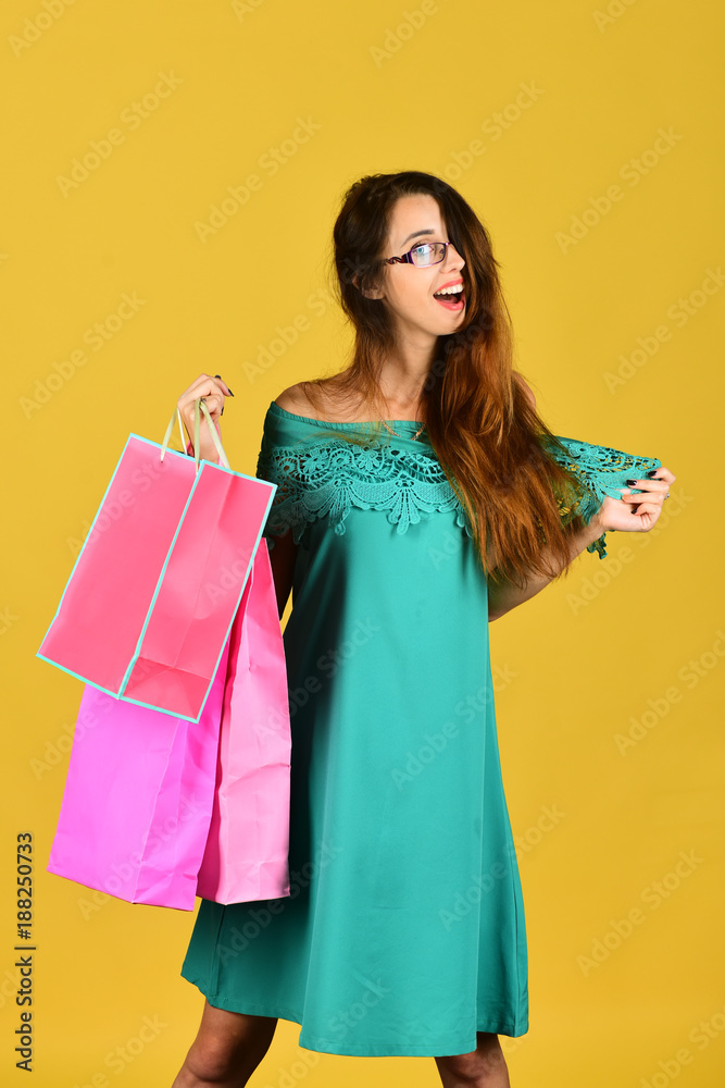 Shopping and leisure concept. Lady stands on yellow background Shopping and leisure concept. Lady stands on yellow background