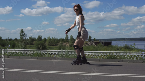 young girl in shorts and tops skates on roller skates