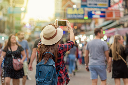 Canvas Print Back side of Young Asian traveling women taking photo in Khaosan Road walking st