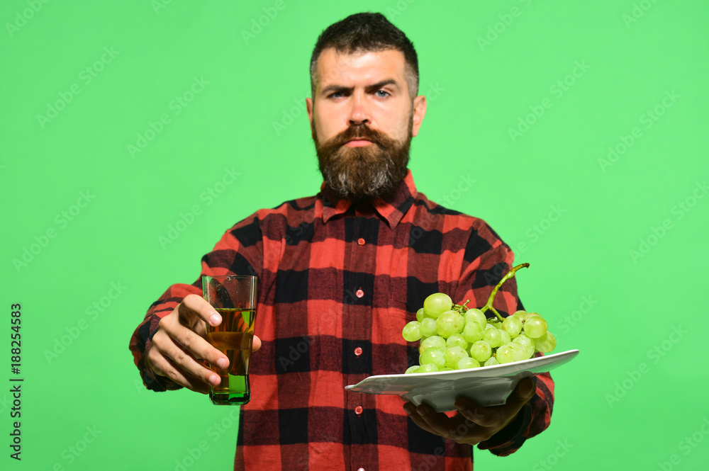 Man with beard holds glass of grape juice or wine Man with beard holds glass of grape juice or wine