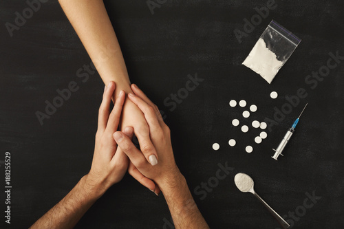 Foto Drug addict hands on dark table