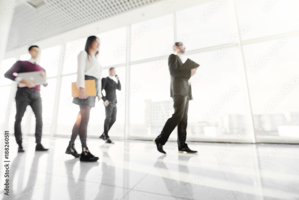 Business team with folders walking along office building and talking Business team with folders walking along office building and talking