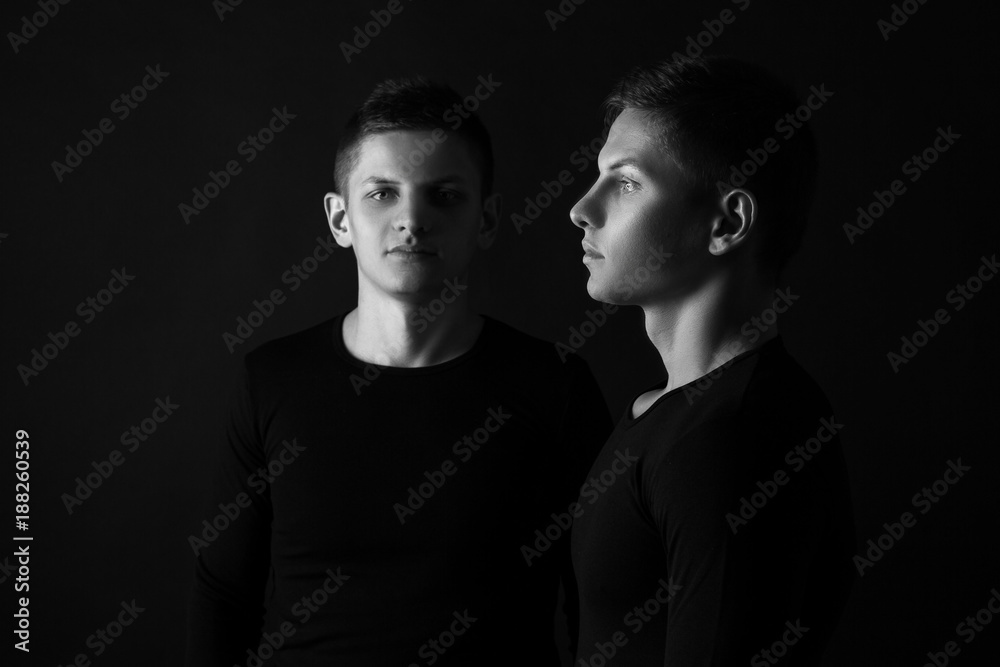 Two attractive positive young twin brothers standing dressed in Two attractive positive young twin brothers standing dressed in