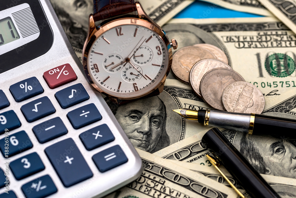 conceptual clock, calculator on the background of dollar bills conceptual clock, calculator on the background of dollar bills