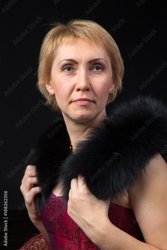 portrait of blonde adult woman with fur collar on black background portrait of blonde adult woman with fur collar on black background