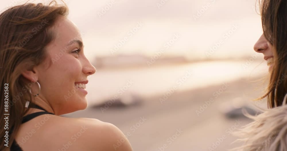 Two beautiful girls talking at sunset Two beautiful girls talking at sunset