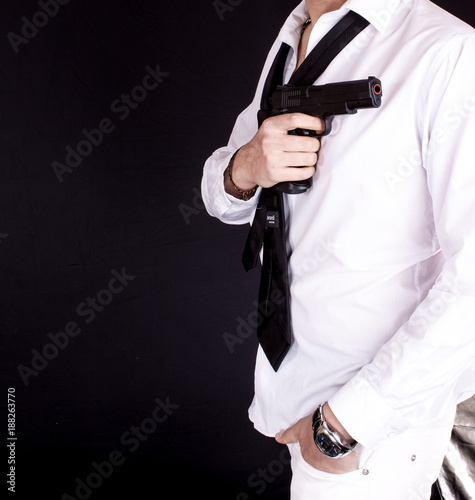 Man in black suit holding gun in hand. Secret agent, mafia, bodyguard concept. © bluebeat76