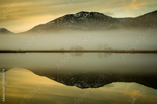 landscape view of scotland and loch tulla at blue hour in winter with calm waters and fog  photo