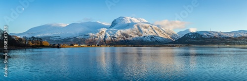 landscape view of scotland and ben nevis near fort william in winter with snow capped mountains and calm blue sky and water photo