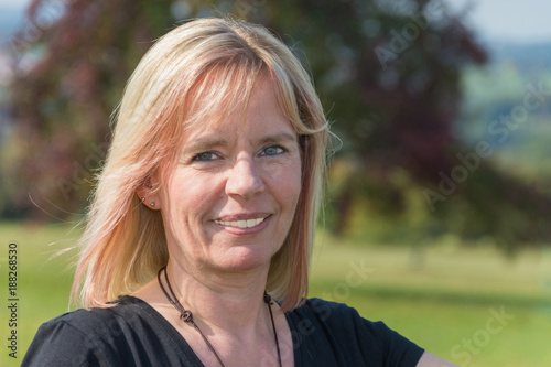Porträt einer Blonde Frau im Sommer mit schwarzem Shirt sieht nach rechts
