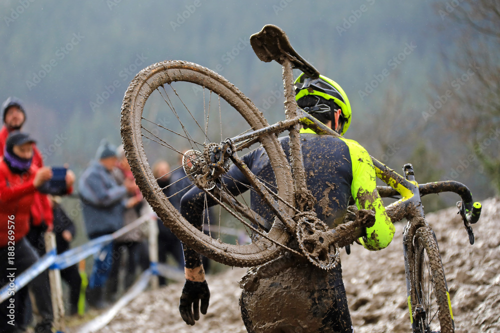 Naklejka premium ciclocross competición ciclista con la bicicleta al hombro en pista de barro país vasco 4M0A4594-f18
