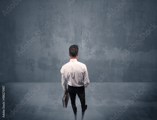 Businessman standing in front of urban wall