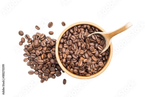 Coffee beans in a wooden bowl with a spoon and a pile next to it seen from above isolated on white background